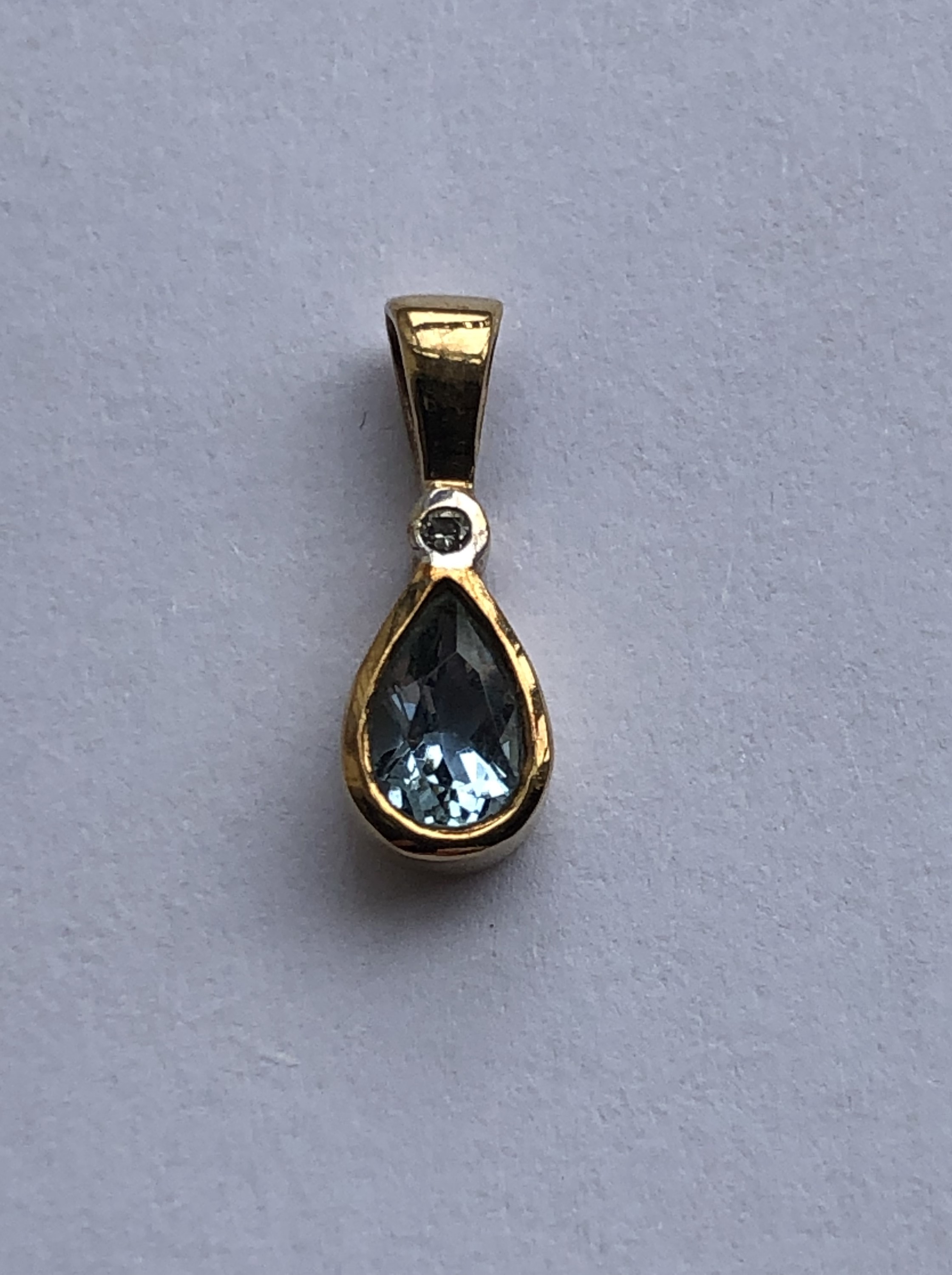 A contemporary yellow-metal, diamond and aquamarine pendant, the brilliant-cut diamond bezel set