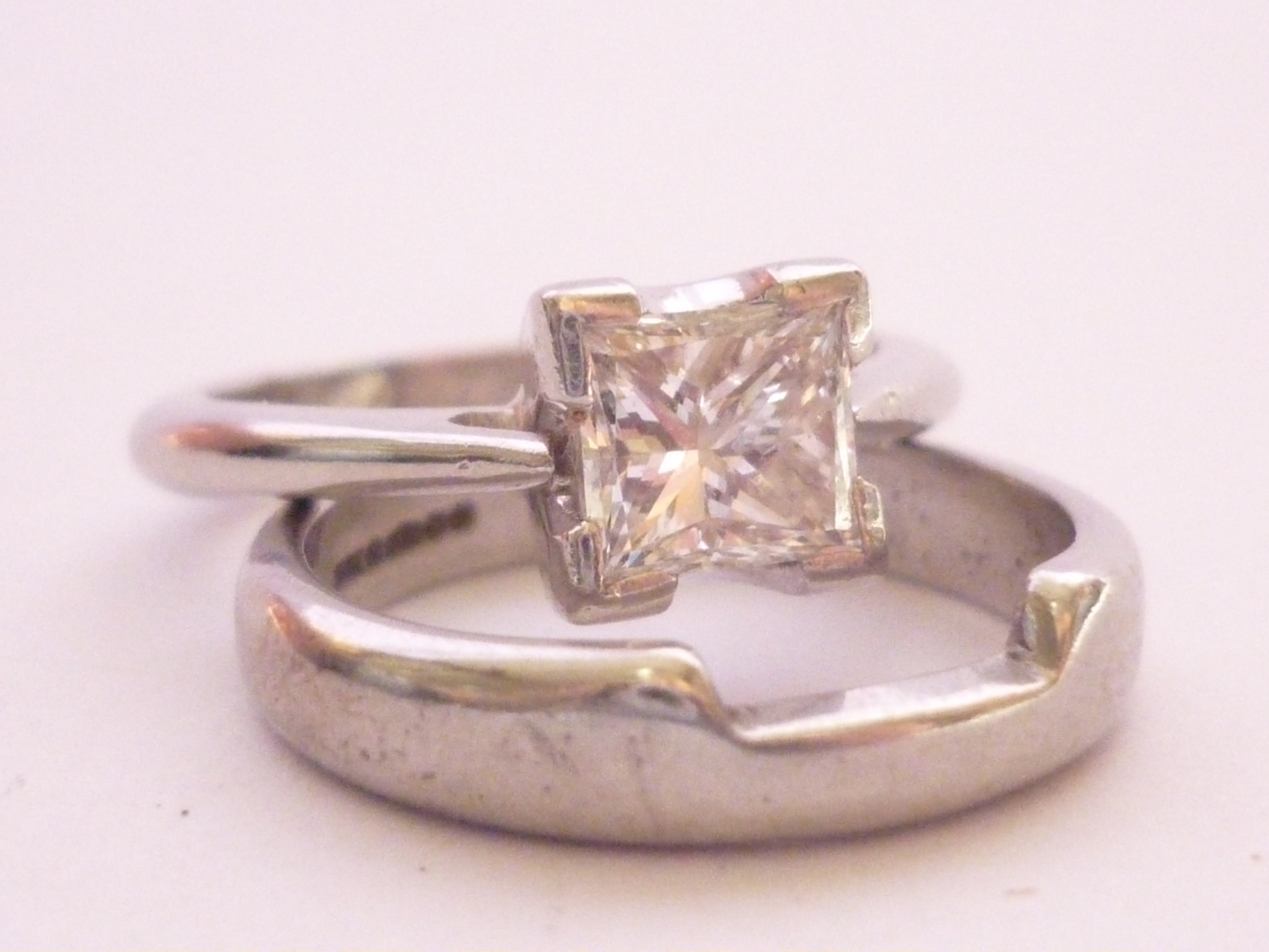 A contemporary platinum and princess-cut diamond solitaire ring and matching wedding band, the