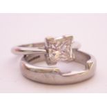 A contemporary platinum and princess-cut diamond solitaire ring and matching wedding band, the