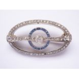 An Art Deco sapphire and diamond brooch, in an openwork annular arrangement, having a central collet