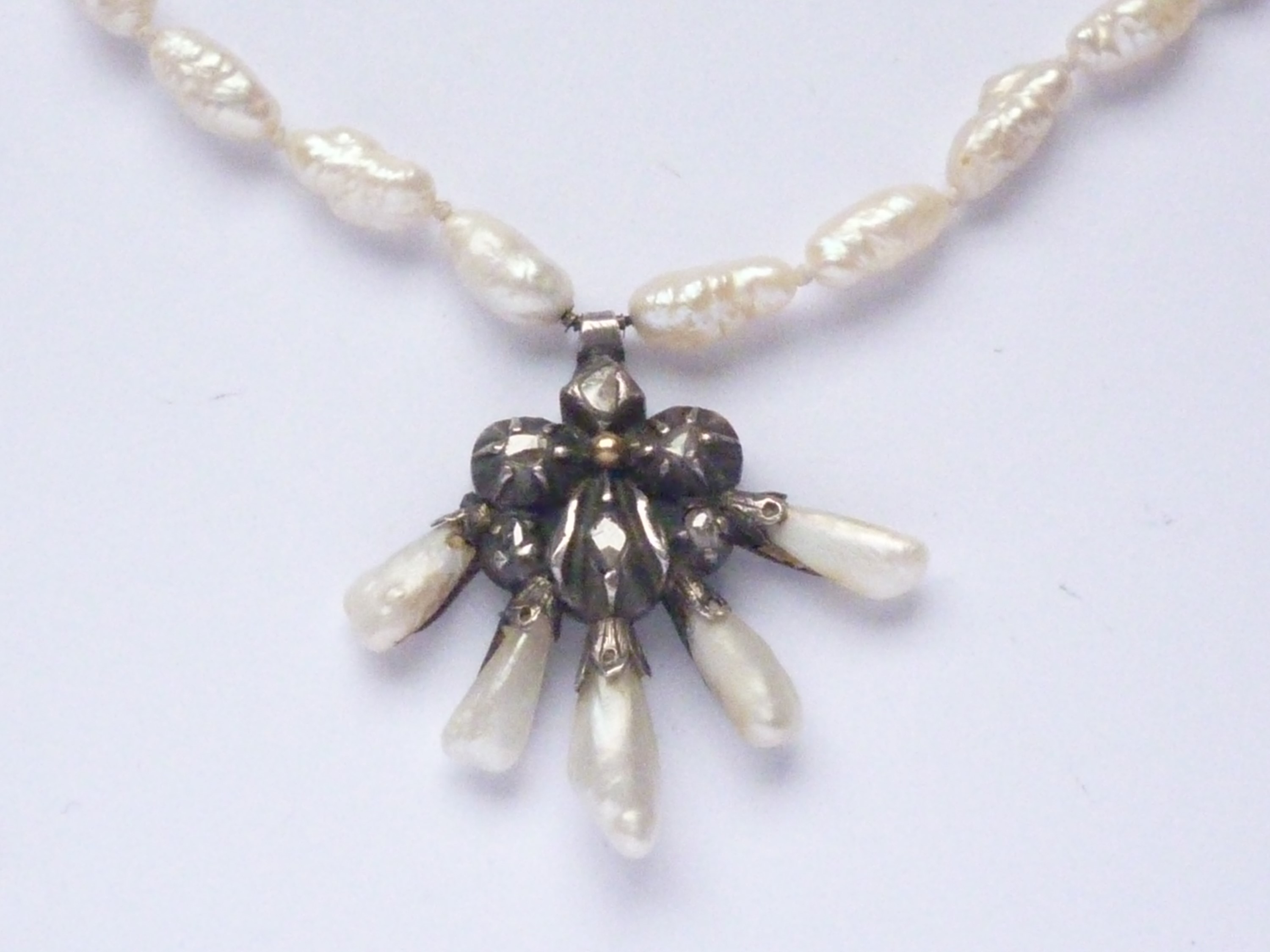 A Georgian white-metal, diamond and baroque pearl pendant necklace, with pansy-shaped flower-head