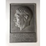 A German Third Reich cast alloy plaque depicting Hitler's profile in relief and bearing the legend