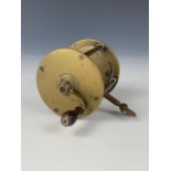 An antique brass centre-pin fishing reel, 3 1/4" diameter