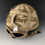 A British Army Kevlar helmet, desert camouflage cover and goggles