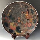 A Meiji Japanese Totai cloisonné / porcelain charger depicting a bird in flight amongst blossom on a
