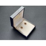 A pair of 9ct gold and garnet stud earrings, each having an oval-cut stone of approximately 1ct,