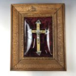 An early 20th century crucifix, framed under a convex glass, 45 x 37 cm