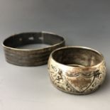 A white metal (tests as silver) bangle with engine-turned decoration, and a silver napkin ring, 33g