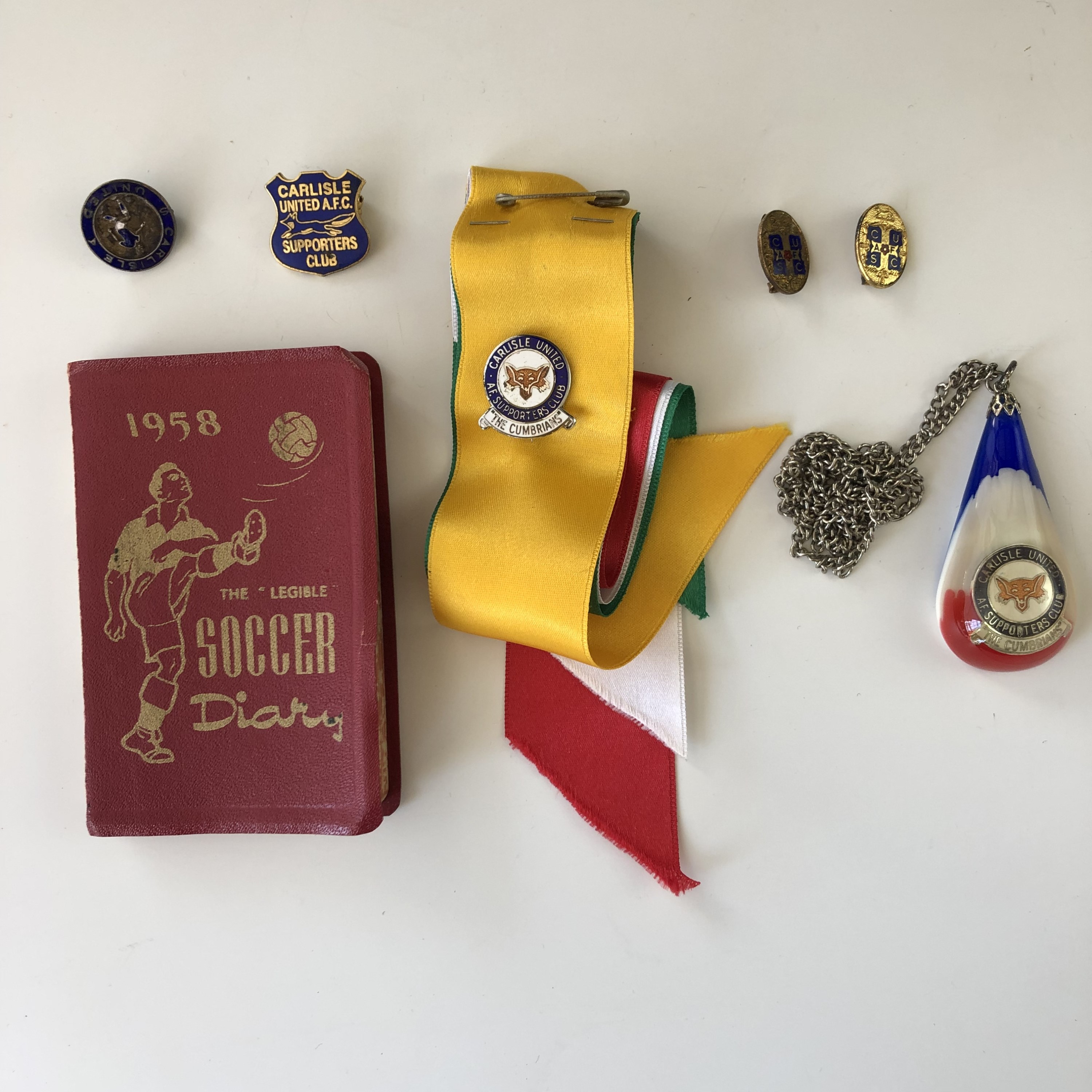 A 1958 "Soccer Diary", Carlisle United Football Club lapel badges and a pendant