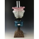 A Victorian oil lamp, having cast pyramidal base, vivid blue glass reservoir and Art Nouveau