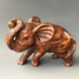 A Japanese carved wooden netsuke modelled as an elephant