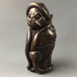 A Japanese carved wood netsuke modelled as a cat-like animal wrapped in a lily pad