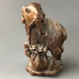 A Japanese carved wood netsuke modelled as a goat