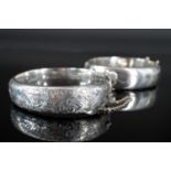 Two 1940s silver hinged bangles, each with foliate engraved decoration to the face, Chester, 1947