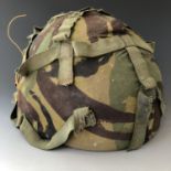 A British Army Kevlar helmet and camouflage cover