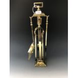 An early 20th Century brass fireside companion set