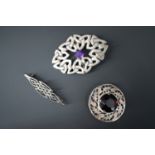 A silver and amethyst Celtic strapwork brooch and two others similar in white metal (test as silver)