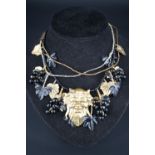 A vintage gilt-metal and Lucite necklace incorporating the mask of Bacchus and fruiting vines,