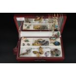 A contemporary red leather jewellery box containing vintage and modern costume jewellery,