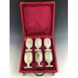 A cased set of six turned and polished onyx wine glasses / goblets