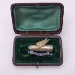 A Great War enamelled and parcel-gilt silver "Speed Up Munitions" brooch modelled as a winged