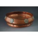 An Arts and Crafts hand-raised hammered copper dish, of circular section, with bulbous rim and