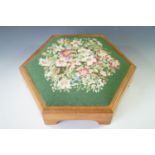 A vintage hexagonal footstool with floral tapestry upholstery