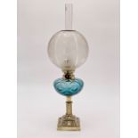 A Victorian brass columnar oil lamp having a blue glass reservoir and frosted and cut glass globe