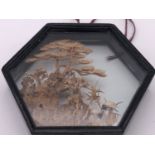 An oriental miniature carved cork diorama depicting two storks amid foliage, framed under glass, 9 x