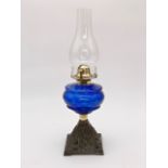 A Victorian oil lamp having a blue glass reservoir