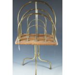 An Edwardian oak and brass floor standing magazine rack