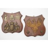 Two wooden shield-shaped plaques faced with military badges