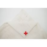 An early 20th Century nurse's cotton head square bearing an embroidered red cross