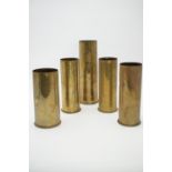 Four Great War artillery shell cases together with a 1942 25-pounder shell case