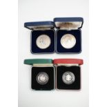 Four silver / silver proof commemorative coins, including two cased Royal Mint £1 / one pound coins,