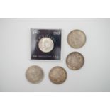 Four various US silver dollar coins and a 1964 President Kennedy half dollar