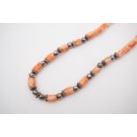 A 1920s carved coral and white-metal necklace, the coral beads in the form of tulip heads,