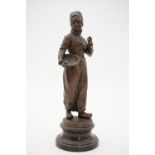 A late 19th / early 20th century bronzed statuette of a Dutch fisherman holding a pipe and basket,