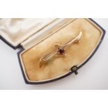 An antique Aesthetic influence 9ct gold and garnet 'bat wing' bar brooch, the garnet of