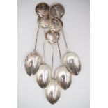 Five 1920s silver golf prize spoons, each terminal containing a vignette of a lady golfer, supported
