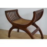 A 1930s cane-seated walnut X-frame stool
