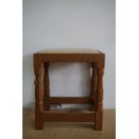 A Robert "Mouseman" Thompson of Kilburn carved oak dressing table stool, having a hide-upholstered