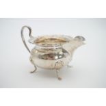 A 1920s silver sugar bowl and cream jug, each of oblate form with a Chippendale style rim flange and