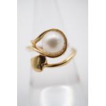 A contemporary high-carat yellow metal and pearl dress ring, the pearl sphere held within an