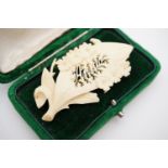 A 19th Century carved bone brooch in the form of a flower sprigged leaf, reticulated with the