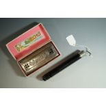 A cased Hohner "The Echo Harp" harmonica and a Swanee whistle