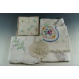 A quantity of vintage textiles including hand-embroidered table cloths