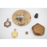 A silver Charles Horner No. 10 thimble, two prize fobs, a brass die, and powder compacts including