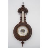 A Victorian carved oak aneroid barometer