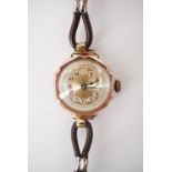 A lady's 9ct rose gold cased wrist watch, with gilt face and Arabic numerals, on a leather strap,